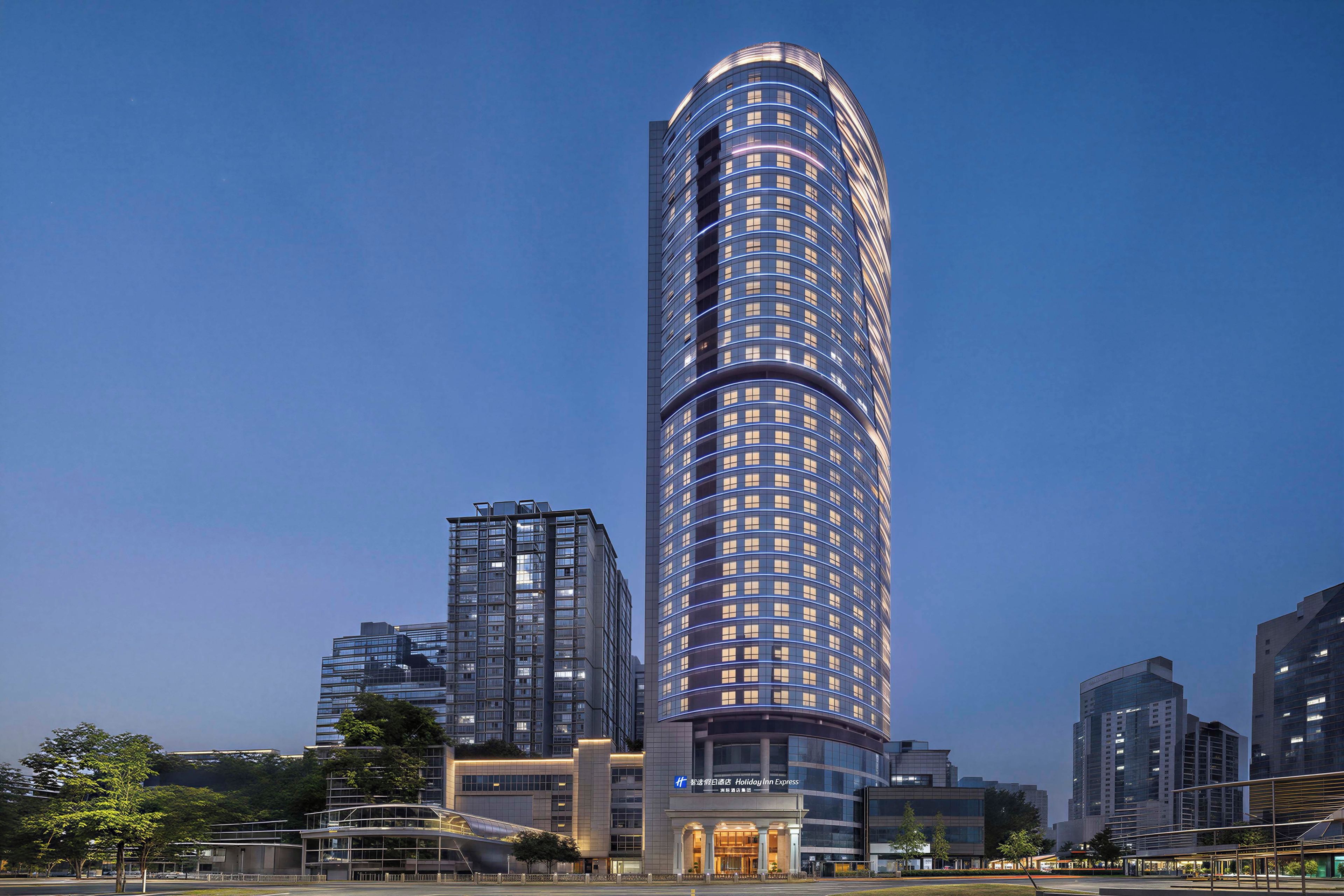 Un hotel alto y moderno con fachada curva y una entrada destacada.
