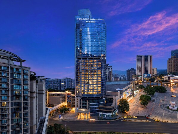 A high-rise hotel with a modern glass facade, located in an urban setting with surrounding high-rise buildings. - Holiday Inn Express Chongqing Yangjiaping by IHG (Chongqing)
