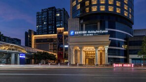 A modern hotel building with a curved facade and illuminated signage. - Holiday Inn Express Chongqing Yangjiaping by IHG (Chongqing)