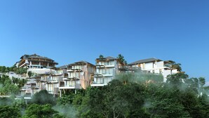 Un hotel de varios pisos con balcones, fachada de piedra y abundante vegetación.