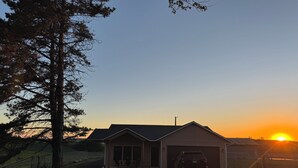 A house with a garage, a driveway, and a parked SUV.