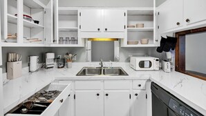 A modern kitchen with white cabinetry, a double sink, a microwave, and a dishwasher. - Southern Oasis-Modern Comfort, Minutes from Downtown (Columbia)