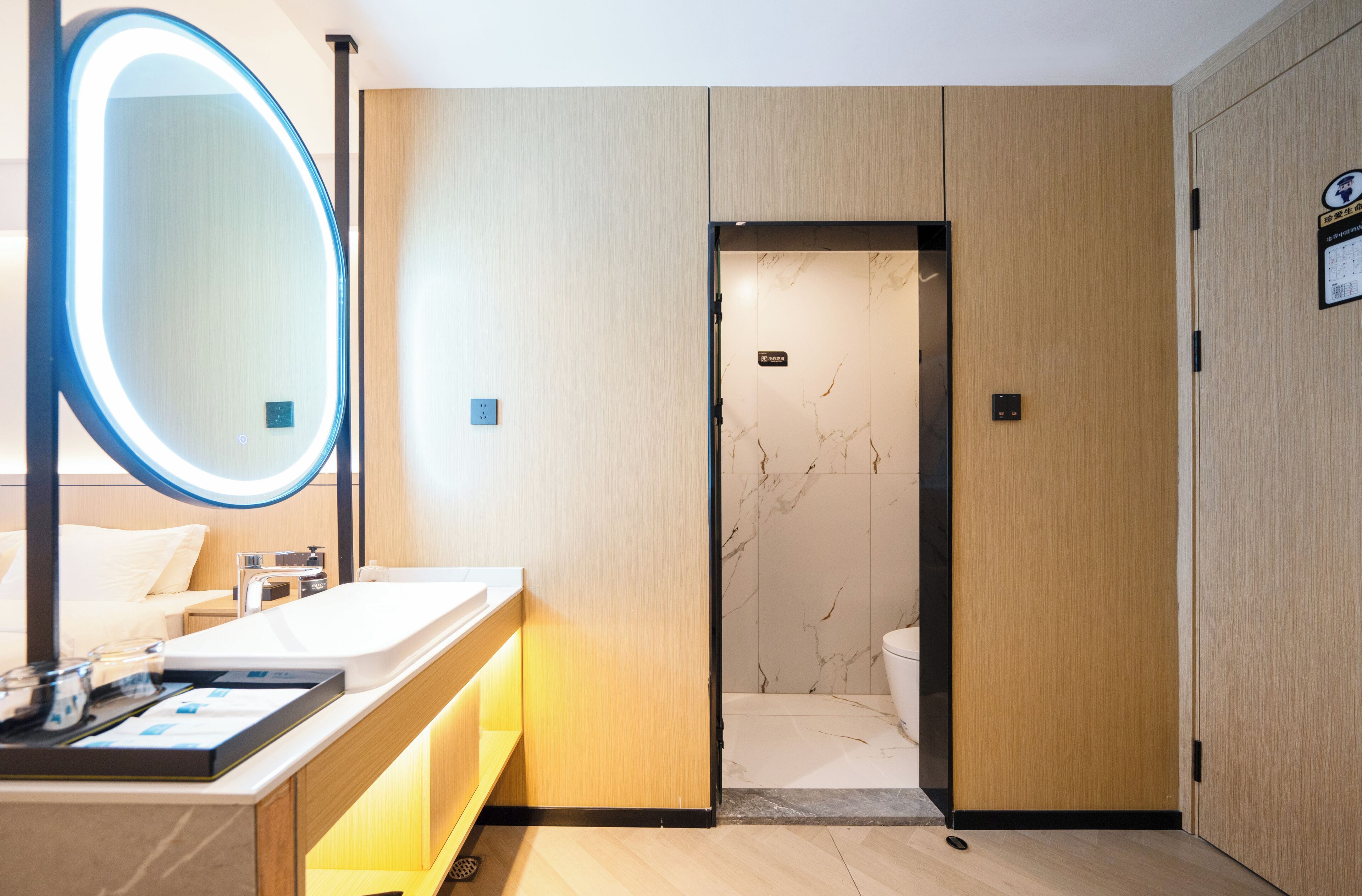 A modern bathroom with a large mirror, a sink, and a toilet.