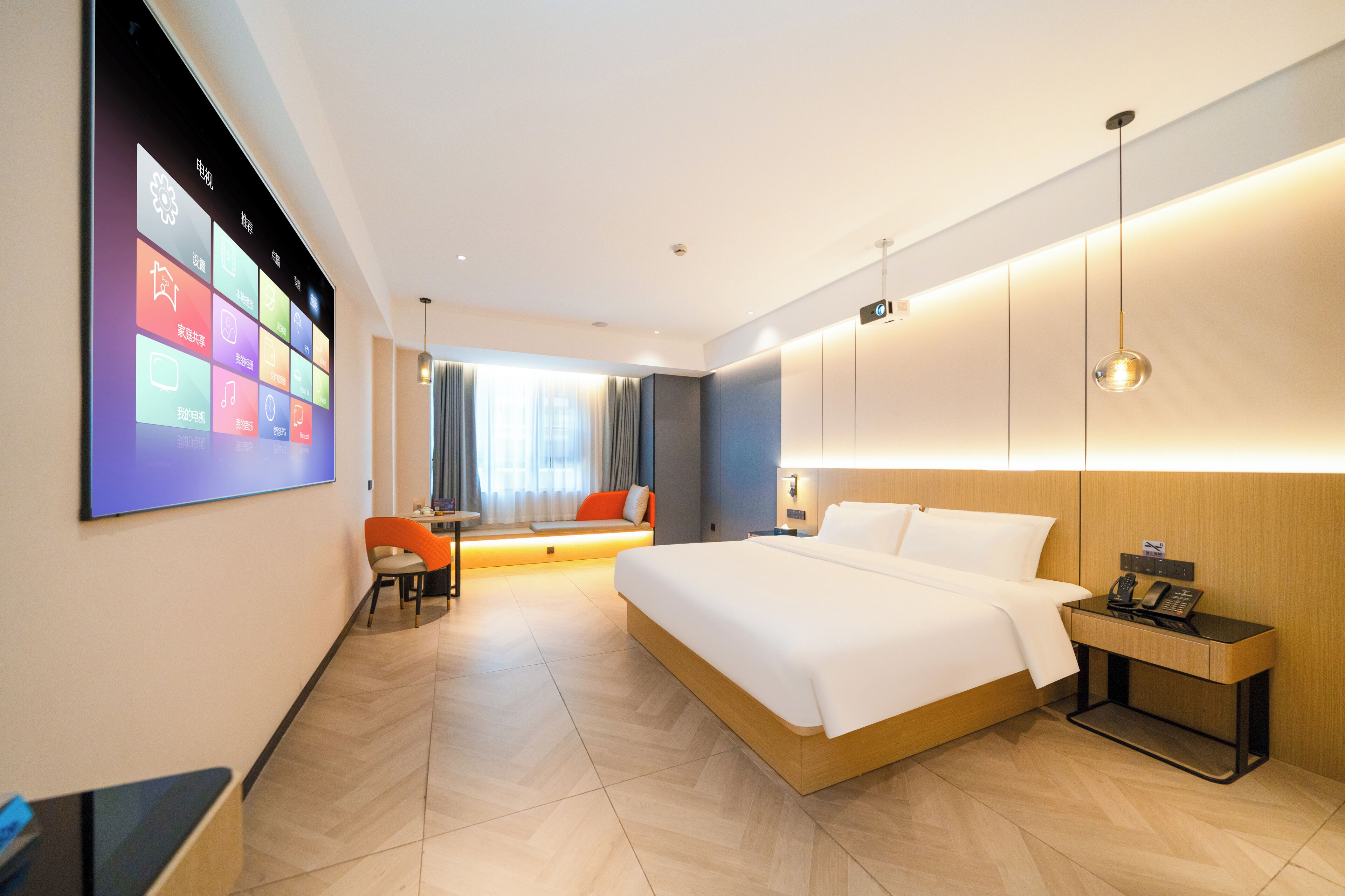 Habitación de hotel con cama, mesita de noche, lámpara y televisor de pared que muestra iconos de aplicaciones.