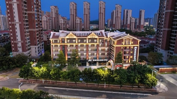 Un hotel con varios pisos, una entrada destacada y un entorno urbano con edificios altos.