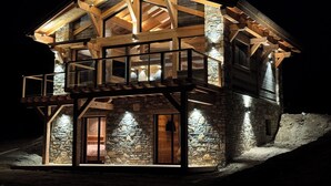 A multi-level wooden cabin with stone walls, a balcony, and a staircase. - Luxury 115-square-meter chalet in a ski resort, ideal for two families (8–10 people) (Saint-Pierre-dels-Forcats)