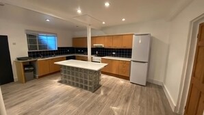 Una cocina moderna con armarios de madera, una isla central y un horno empotrado.