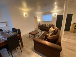 Ein modernes Wohnzimmer mit Essbereich, einer Sofagarnitur und einem Couchtisch.