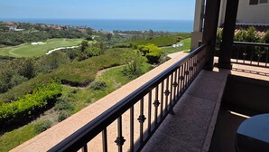 Un balcon avec vue sur un terrain de golf et l’océan.