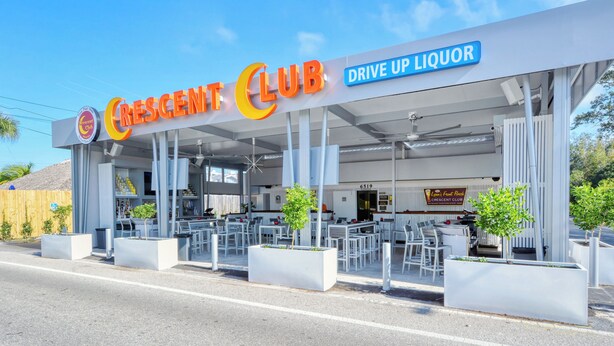 A drive-up liquor service at Crescent Club with outdoor seating and a clear sky. - Waterfront Home with Pool & Dock (Siesta Key)