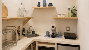 Cocina compacta con microondas, refrigerador y estantes de madera.