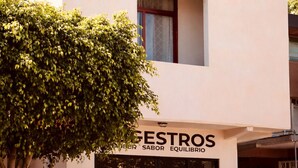 Un edificio de dos pisos con un letrero que dice 'CASA MAAKJA' y otro letrero debajo que dice 'GESTROS SUEBER SABOR EQUILIBRIO'.
