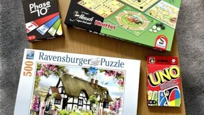Una mesa de madera con diversos juegos de mesa y rompecabezas.