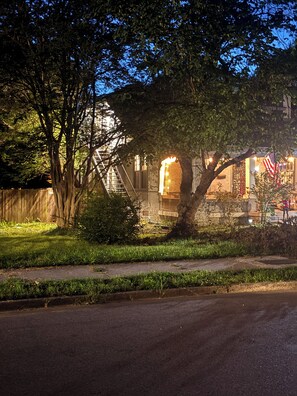 Un quartier résidentiel avec une maison, un arbre et une rue.