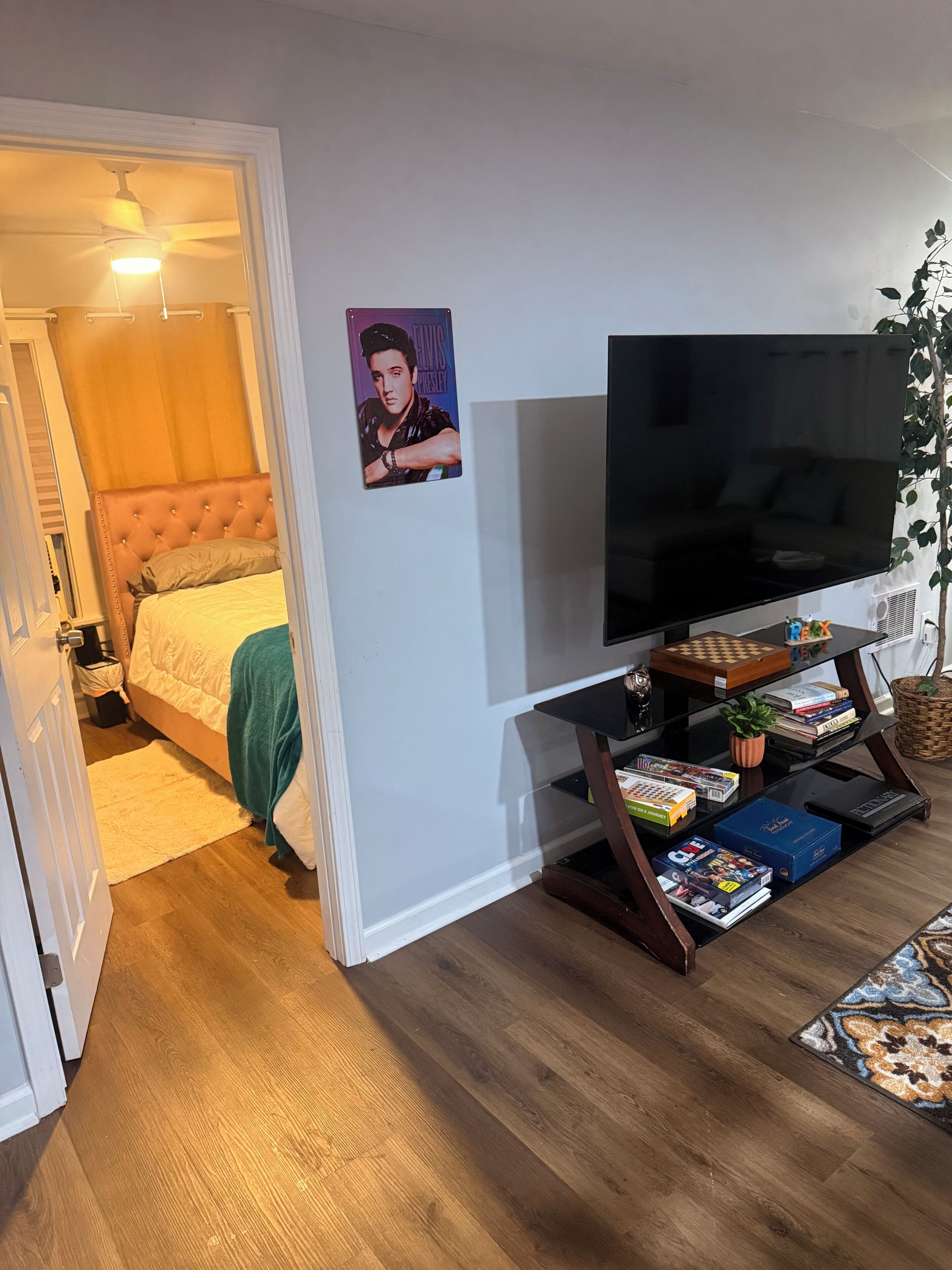 Ett sovrum med en säng, en tv och en bokhylla.