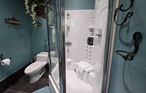 A bathroom with a glass-enclosed shower, a toilet, and a sink.