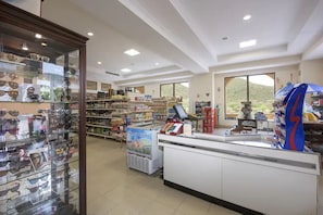 Un magasin avec des étagères remplies de lunettes de soleil et un présentoir réfrigéré.