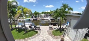 A view of a pool area with palm trees, a pathway, and a building in the background. - Boaters dream! Waterfront home in Bonita Springs - Estero Bay in minutes (Bonita Springs)
