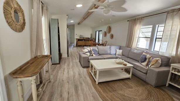 A spacious living area with a sectional sofa, a coffee table, and a ceiling fan. - Boaters dream! Waterfront home in Bonita Springs - Estero Bay in minutes (Bonita Springs)