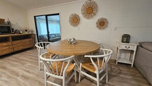 A dining area with a round wooden table, white chairs, and three wall-mounted decorative items. - Boaters dream! Waterfront home in Bonita Springs - Estero Bay in minutes (Bonita Springs)