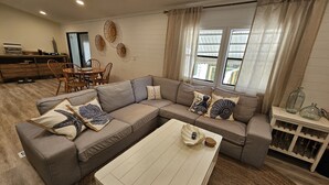 A living room with a sectional sofa, a coffee table, and a dining area with chairs and a table. - Boaters dream! Waterfront home in Bonita Springs - Estero Bay in minutes (Bonita Springs)