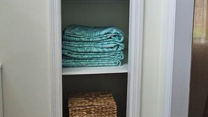A closet with shelves, a folded blanket, and a woven basket. - Boaters dream! Waterfront home in Bonita Springs - Estero Bay in minutes (Bonita Springs)