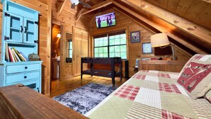 A cozy attic bedroom with a wooden ceiling, a ceiling fan, a bed with a quilt, a desk with a lamp, and a TV mounted on the wall. - Hot Tub • Pet Friendly • 12 Min to Blue Ridge (Blue Ridge)