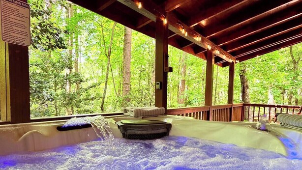 A hot tub with a view of a forest, a wooden deck, and a safety rules sign. - Hot Tub • Pet Friendly • 12 Min to Blue Ridge (Blue Ridge)