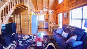 A wooden cabin interior with a living room, dining area, kitchen, and a staircase. - Hot Tub • Pet Friendly • 12 Min to Blue Ridge (Blue Ridge)