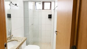 A bathroom with a toilet, sink, mirror, and shower area. - Apartment with balcony and sea view, 3 minutes from Atalaia beach. (Luís Correia)