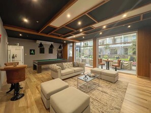 A spacious living area with a pool table, comfortable seating, and large windows offering a view of the outdoors. - Geko | Cozy loft w/ Balcony in Barranco (Barranco)