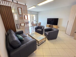 A modern living room with a sofa, armchairs, a coffee table, and a TV. - Villa Norma by Interhome (Cannes)