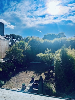 A garden with a wooden structure, dense foliage, and a clear sky. - The Enclosed Garden of Cancale (Cancale)