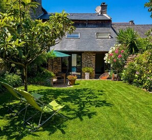 A house with a stone facade, a sloped roof, and a well-maintained lawn. - The Enclosed Garden of Cancale (Cancale)