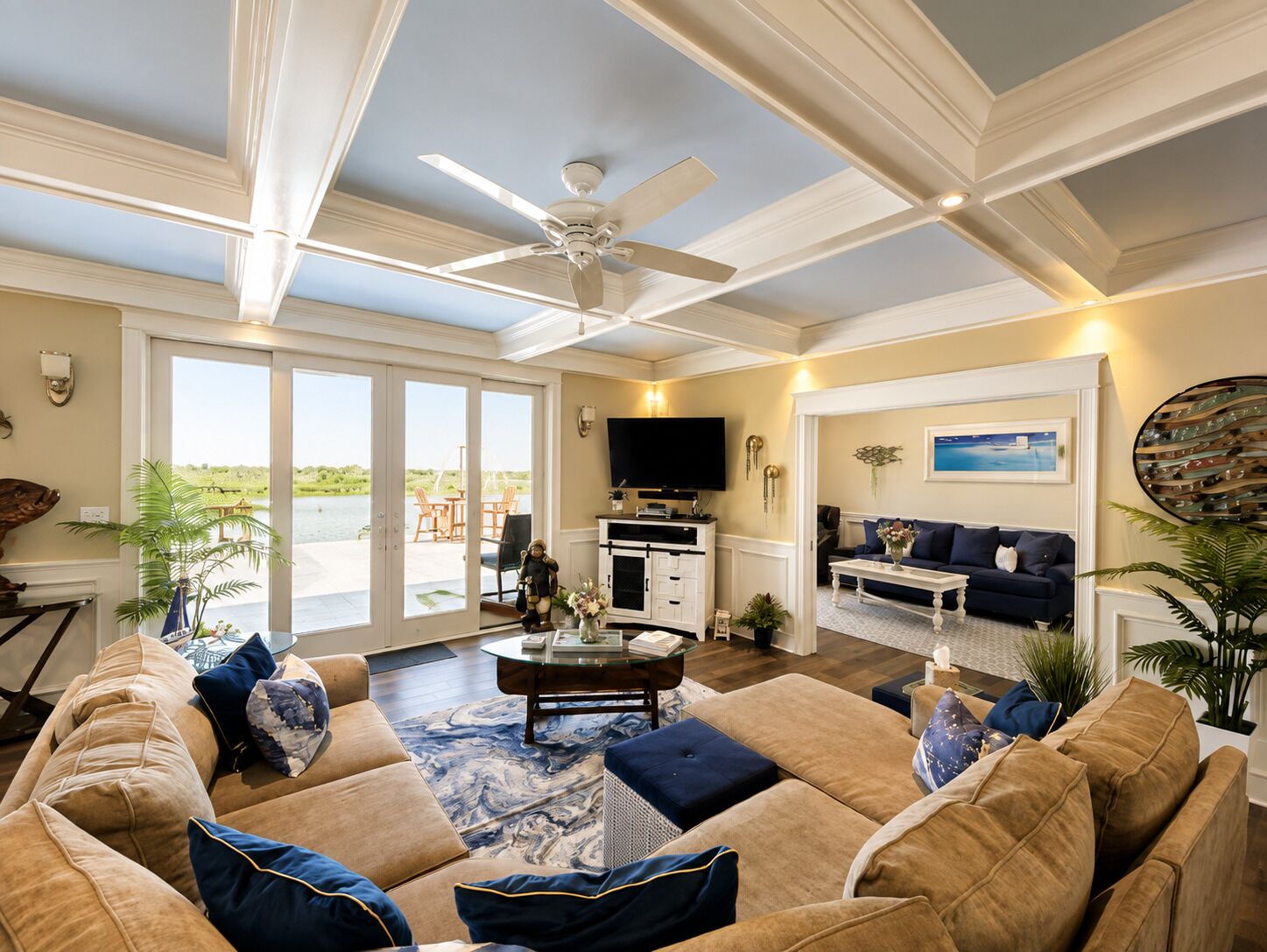 A spacious living room with a ceiling fan, a fireplace, a television, and a view of the outdoors through large sliding doors.