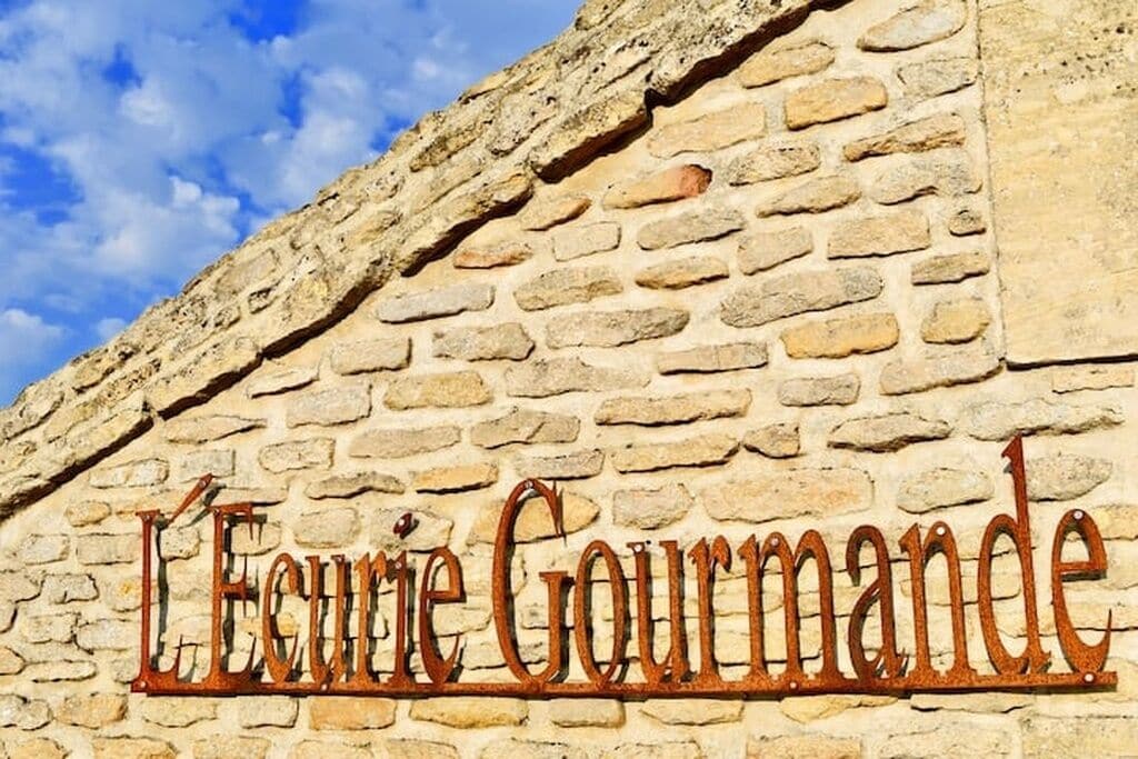 A stone wall with the inscription 'L'Ecoute Gourmande.'