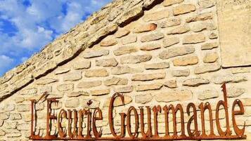 A stone wall with the inscription 'L'Ecoute Gourmande.'
