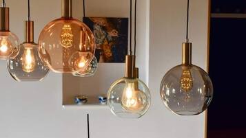Een reeks hanglampen met heldere glazen kappen en koperkleurige schachten.