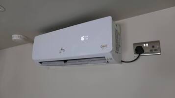 A white air conditioning unit mounted on a wall with a digital display showing 16 degrees.