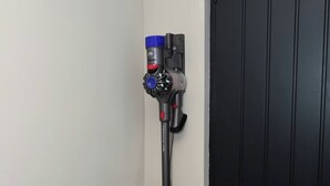 A vacuum cleaner mounted on a wall near a door. - White Bungalow With 75" Tv, Air Con, Contractors (Bradford)