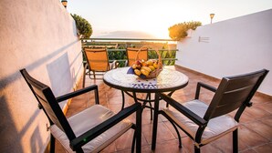 A round table with chairs, a basket of fruit, and a view of the landscape. - El Navio (Guia de Isora)