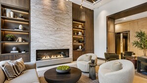 A modern living room with a fireplace, built-in shelving, and comfortable seating. - Luxury Downtown Dallas High-Rise Pool Gym & Views (Dallas)
