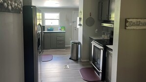 Una cocina con refrigerador, estufa y armarios.