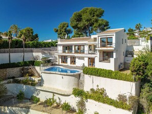 A modern two-story house with a swimming pool, surrounded by greenery and a clear blue sky. - Vacation home Bartok by Interhome (Jávea)