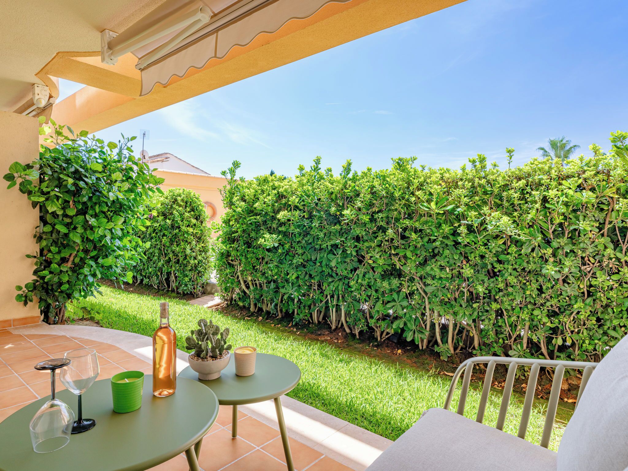 Eine Terrasse mit Tisch, Stühlen und einem Blumentopf.