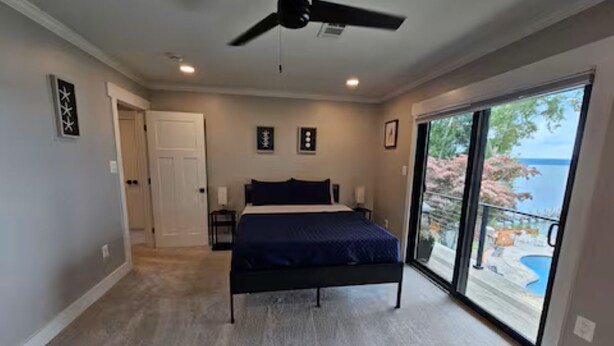 Una camera da letto con un letto, una ventola a soffitto, una porta e vista su una piscina attraverso una porta in vetro.