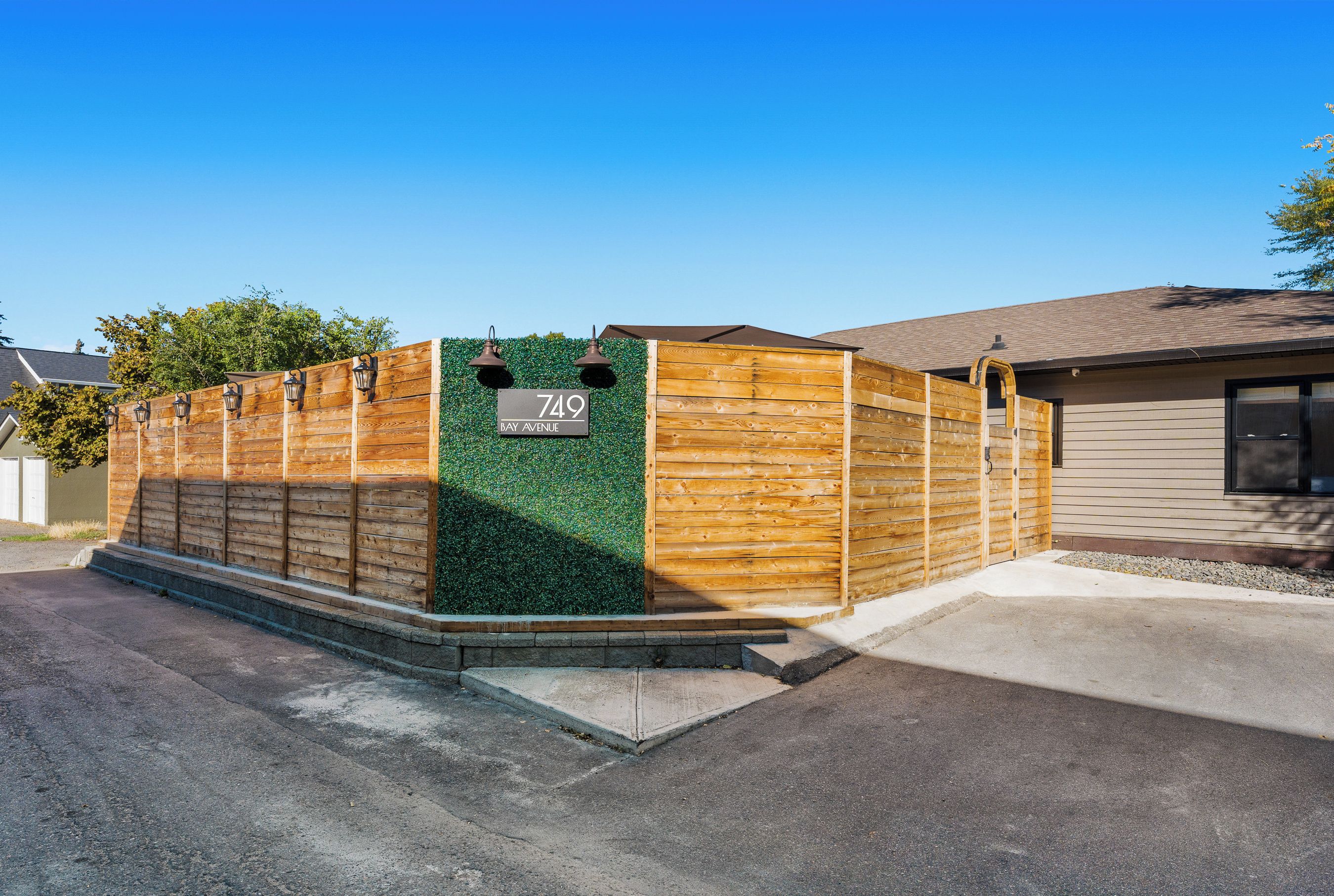 A residential property with a wooden fence, a green wall, and a house number 749.
