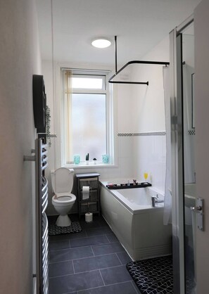 Un baño pequeño con inodoro, lavamanos, bañera y ducha.