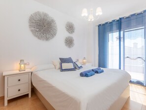 Ein Schlafzimmer mit einem Bett, zwei Nachttischen, einer Chandelierleuchtre und dekorativer Wandgestaltung.