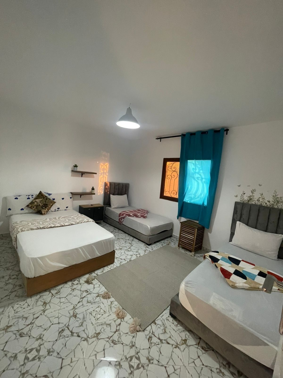 Une chambre avec deux lits, un canapé, une petite table et une table de chevet.